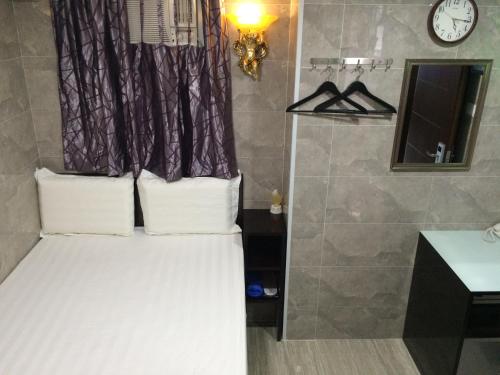 a small bedroom with a bed and a shower at Victoria Inn in Hong Kong
