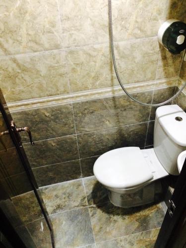 a bathroom with a toilet and a shower at Victoria Inn in Hong Kong