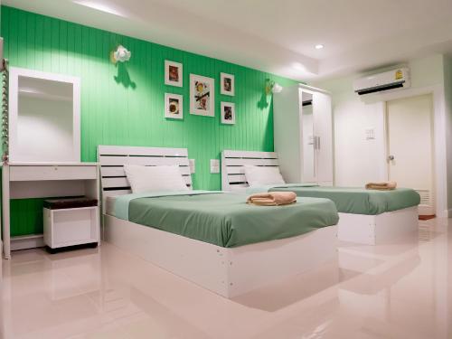 邦賢的住宿－UJ公寓酒店，绿墙客房的两张床