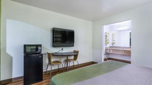 Zimmer mit einem kleinen Tisch und einem TV an der Wand in der Unterkunft Motel 6-San Marcos, TX - North in San Marcos
