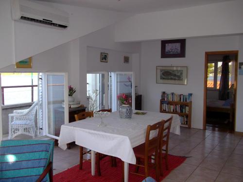 une salle à manger avec une table et des chaises blanches dans l'établissement Soline accommodation, à Korčula