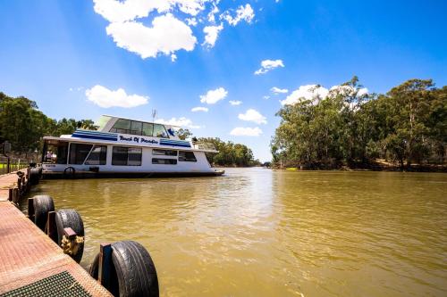 a boat is docked at a dock on a river at Tasman Holiday Parks - Merool on the Murray in Echuca