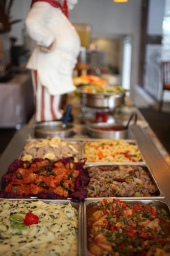 a person in a kitchen with a bunch of food at Hotel Ciros in Pachuca de Soto