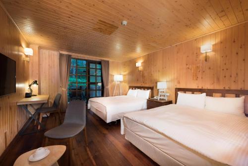 um quarto de hotel com duas camas e uma televisão em Ming Chi Shan Zhuang em Datong