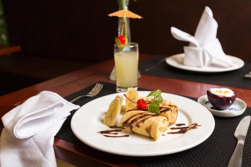 a table with a plate of food and a glass of orange juice at Splendid Star Grand Hotel and Spa in Hanoi