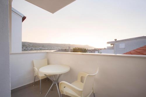 a room with a table and chairs on a balcony at Boutique Hotel Intermezzo - Pag centre in Pag