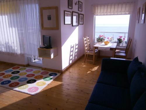 a living room with a couch and a television and a table at Villa Flaga in Sozopol