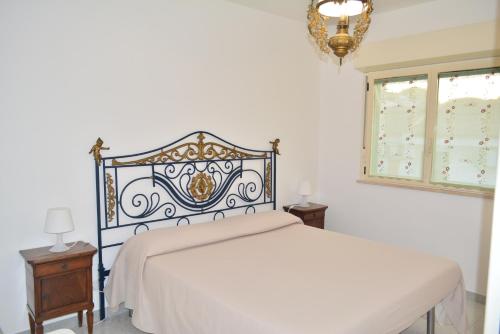 a bedroom with a white bed and a chandelier at Nido dei gabbiani in Bisceglie
