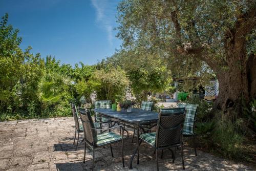 a table and chairs sitting under a tree at Agriturismo Salinola in Ostuni