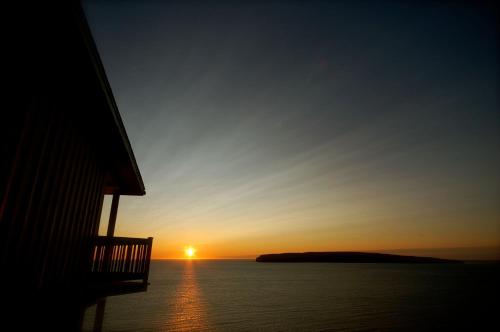 a view of the sunset from a house at Hôtel La Côte Surprise in Perce