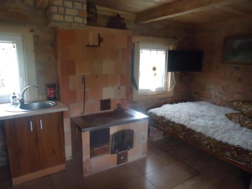 a small room with a bed and a sink and a sink at Namelis in Einoriai