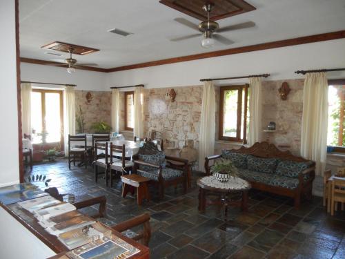 ein Wohnzimmer mit Stühlen, Tischen und Fenstern in der Unterkunft Pythaïs Hotel in Pythagoreio