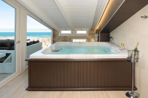 a jacuzzi tub in a room with a large window at Opera Arte Suite Apartments in Porto Recanati