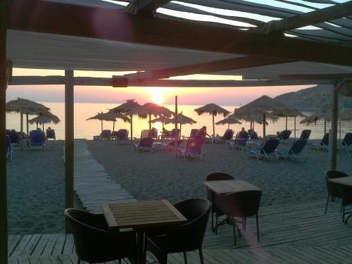 a beach with chairs and tables and umbrellas at Cavo Christo in Petra