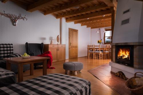 a living room with a fireplace and a dining room at Liptovské Chaty in Liptovský Mikuláš