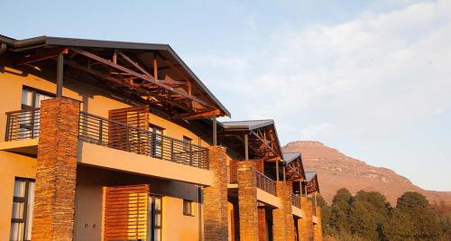 a building with a mountain in the background at Premier Resort Sani Pass in Himeville