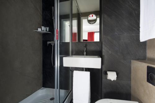 a bathroom with a sink and a shower at Hotel Pilime in Paris