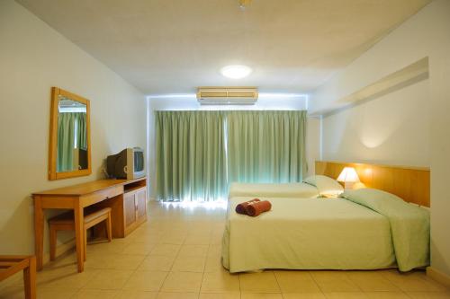 a bedroom with a bed and a desk and a television at Diamond City Place in Pattaya South