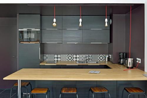 a kitchen with a wooden counter and some stools at Quintessens in Marseille