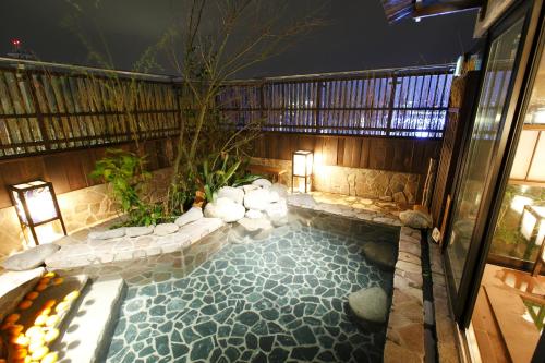 a swimming pool in the middle of a house at Dormy Inn Kagoshima in Kagoshima