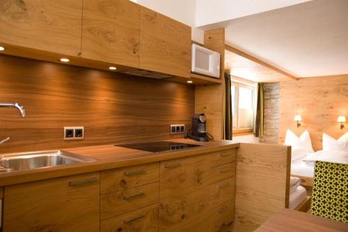 - une cuisine avec des murs en bois et un lavabo dans la chambre dans l'établissement Haus Battisti, à Sankt Anton am Arlberg