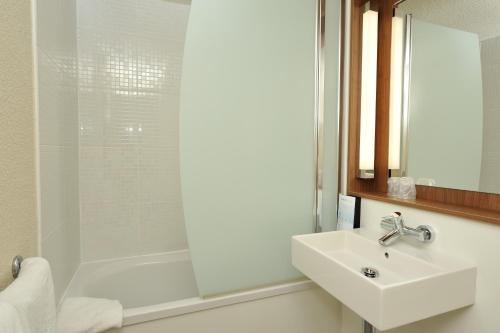 a white bathroom with a sink and a shower at Campanile Grenoble Sud - Seyssins in Seyssins