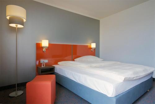 um quarto com uma cama grande e uma parede vermelha em iQ-Hotel Ulm em Ulm
