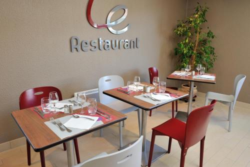 a restaurant with two tables and chairs with wine glasses at Campanile Grenoble Sud - Seyssins in Seyssins