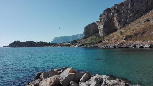 a large body of water next to a mountain at Residenza Wagner in Palermo