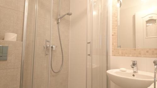 y baño con ducha y lavamanos. en Pokoje Gościnne Apartamenty, en Międzyzdroje