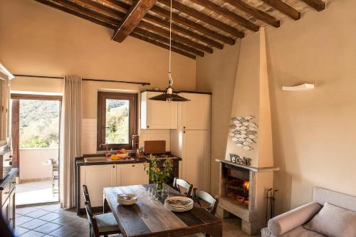 una cucina e un soggiorno con tavolo in legno e sala da pranzo di Agriturismo Galenzana a Marina di Campo