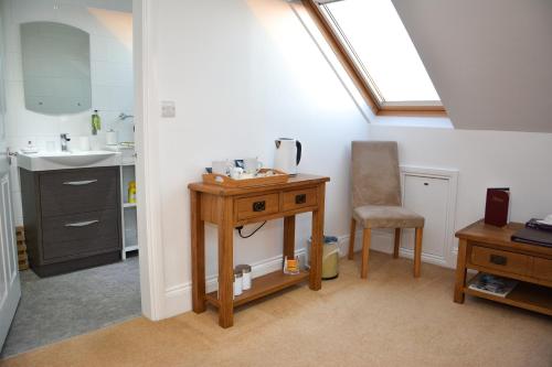 a bathroom with a sink and a desk with a chair at Townend Farm Bed and Breakfast in Loftus