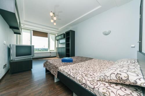 a bedroom with a bed and a flat screen tv at Apartments on Henerala Zhmachenka in Kyiv