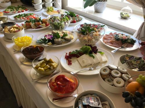 凯尔采维拉胡塔酒店的桌子上摆着许多盘子食物