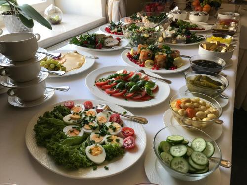 凯尔采维拉胡塔酒店的桌子上摆着许多盘子食物