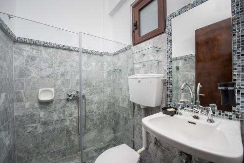 a bathroom with a toilet and a sink and a shower at Pavlimari Studios in Pyrgi Thermis