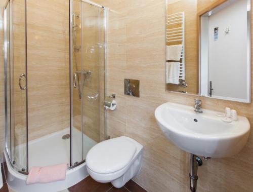 a bathroom with a toilet and a sink and a shower at Jordan Pokoje Gościnne in Krakow