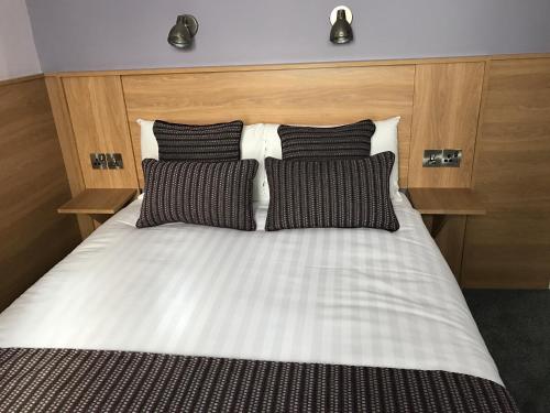 a bed with black and white sheets and pillows at Kennedys B&B Drumcondra in Dublin