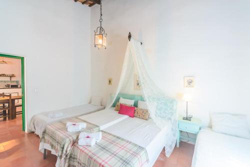 a bedroom with a bed with a mosquito net at Huerta la Pimentada in Palma del Río