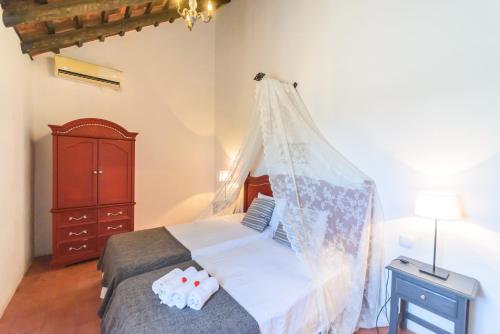 a bedroom with a bed with a mosquito net at Huerta la Pimentada in Palma del Río