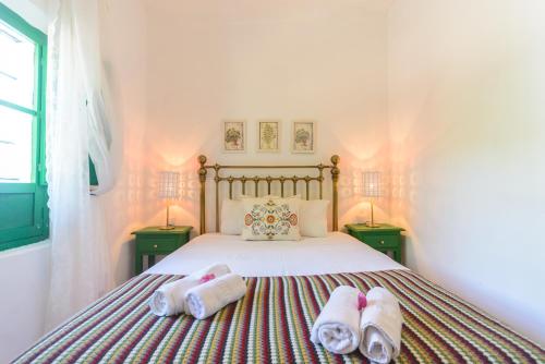 a bedroom with a bed with two towels on it at Huerta la Pimentada in Palma del Río