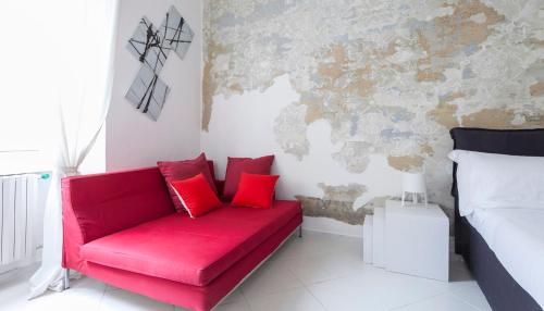 um sofá vermelho com almofadas vermelhas num quarto em Italianway-Porro Lambertenghi em Milão