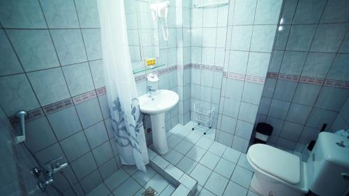 a small bathroom with a sink and a toilet at Saffroni Inn in Paralia Katerinis