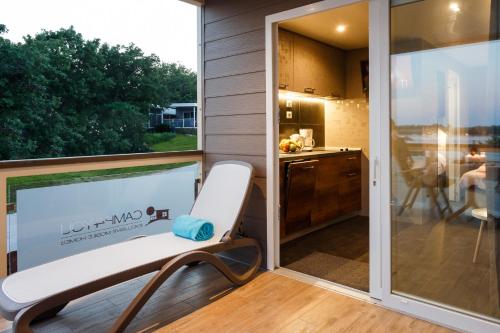 a balcony with a white bench and a kitchen at Mobile Homes - FKK Nudist Camping Solaris in Poreč