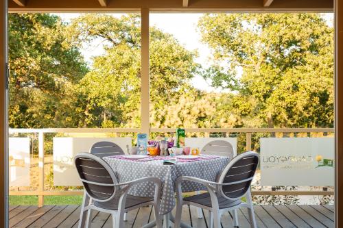 a table and chairs on a deck with a table and chairs at Mobile Homes - FKK Nudist Camping Solaris in Poreč