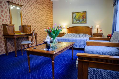 a hotel room with a bed and a table with flowers on it at Hotel Wellness & Spa Nowy Dwór in Rzeszów