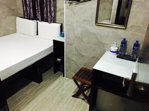 a bathroom with two beds and a chair and a mirror at Victoria Inn in Hong Kong