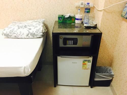 a small refrigerator next to a bed in a room at Victoria Inn in Hong Kong