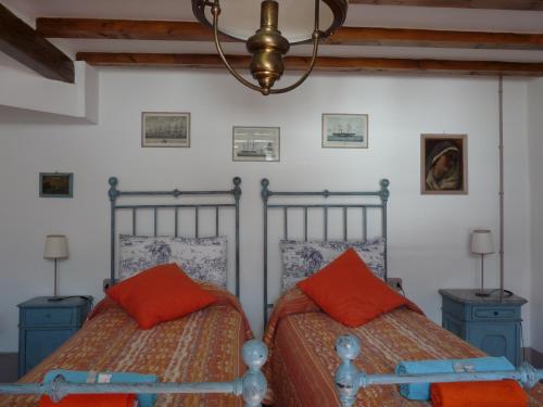 B&B "A Casa di Camilla" في Carate Urio: سريرين مع وسائد برتقالية في غرفة النوم