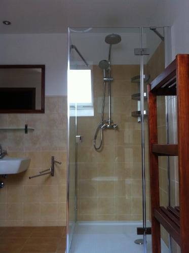 a shower with a glass door in a bathroom at Penzion Terezka in Králíky